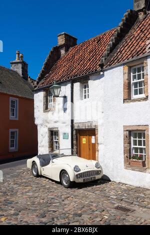 Une voiture de sport Triumph TR3A 1959 devant une ancienne maison traditionnelle dans le beau village de Culross, Fife, Écosse. Banque D'Images