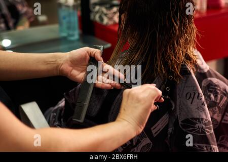 Un gros plan d'un coiffeur coupant les cheveux d'un client. Petite entreprise Banque D'Images