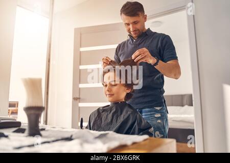 Beau mâle caucasien touchant les cheveux du petit garçon Banque D'Images