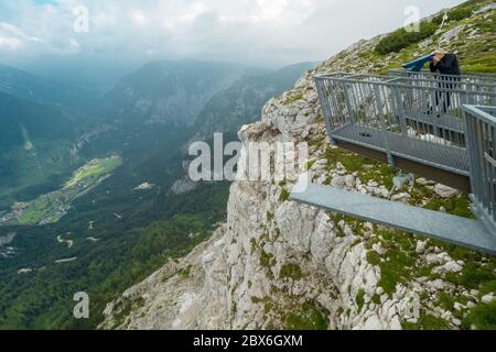 Touriste regardant à travers le télescope à la plate-forme d'observation de 5 doigts sur le sommet de la montagne Krippenstein, région de Salzkammergut, OÖ, Autriche Banque D'Images