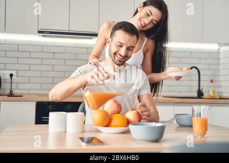 Un jeune couple heureux et marié qui prend le petit déjeuner à la maison Banque D'Images