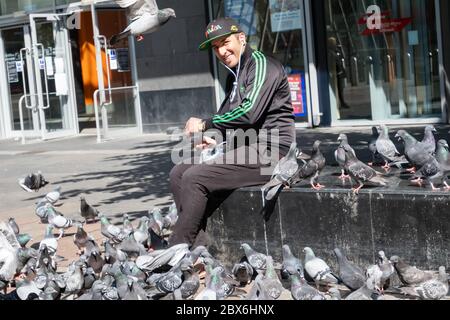 Glasgow, Écosse, Royaume-Uni. 5 juin 2020. Un homme qui nourrit les pigeons sur la place Saint-Hénoc. Le gouvernement écossais a annoncé le 28 mai un assouplissement des règles de verrouillage du coronavirus. Credit: SKULLY/Alay Live News Banque D'Images