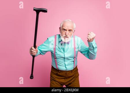 Tais-toi. Photo d'un homme agé agressif lève la canne à pied poing en colère grimace qui accuse les enfants voisins pour le bruit porter chemise bretelles noeud cravate pantalons Banque D'Images