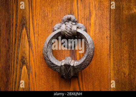 Poignée métallique ronde antique sur une porte avant en bois. Belle couleur marron poignée d'entrée élégante sur la porte. Objet métallique vintage isolé sur bois Banque D'Images