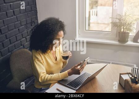 Femme concentrée utilisant son gadget au travail Banque D'Images