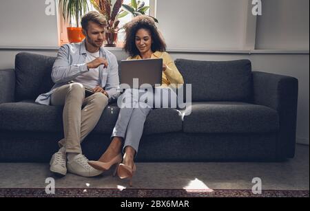 Femme souriante pointant vers l'écran de l'ordinateur portable Banque D'Images