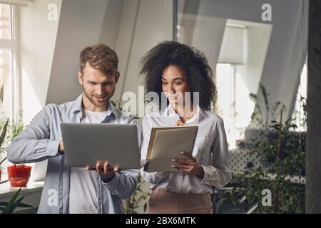 Une dame qui regarde l'ordinateur de son collègue Banque D'Images