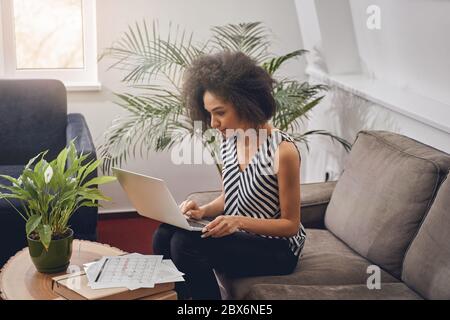 Une femme sérieuse qui est à la surveillance de son moniteur d'ordinateur Banque D'Images