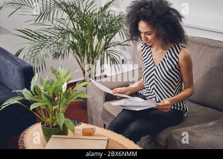 Une sérieuse dame examine les documents dans son bureau Banque D'Images