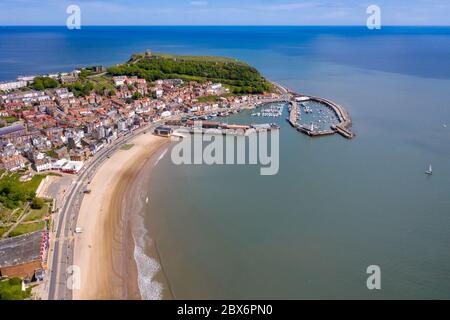 Photo aérienne du centre-ville de Scarborough dans le Yorkshire de l'est, au Royaume-Uni, montrant la plage côtière et le port avec des bateaux et le château de Scarborough Banque D'Images