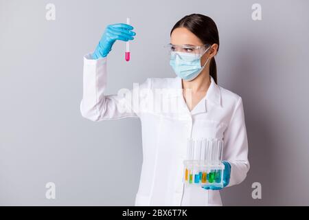 Photo de virologue doc dame expérimentée tenir professionnel tubes à essai comparer les résultats de la sonde de vaccin porter des gants masque facial lunettes de protection Banque D'Images