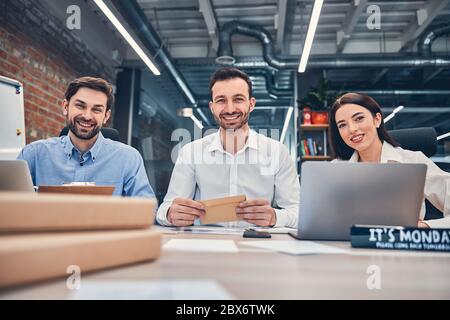 Jeunes collègues souriants travaillant au bureau avec des ordinateurs Banque D'Images