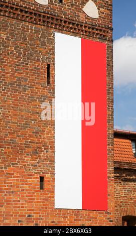 Drapeau de la Pologne à la porte du monastère (Brama Klasztorna) à Torun. Pologne Banque D'Images