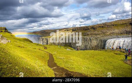 Vue panoramique sur la plus grande et la plus puissante cascade d'Europe appelée Dettifoss en Islande, près du lac Myvatn, avec arc-en-ciel au ciel spectaculaire avec tou Banque D'Images