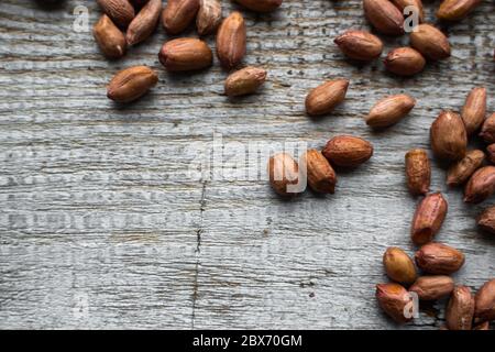 Arachides éparpillées sur la table en bois vintage. Arachides noix est une alimentation saine végétarienne de protéines nutritives. Banque D'Images