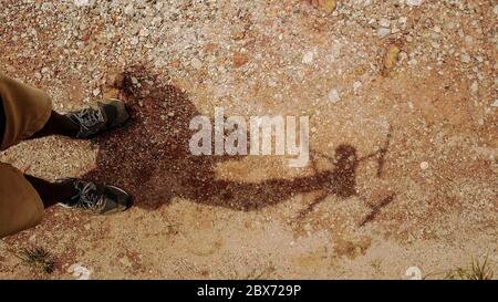 Vue aérienne de haut en bas sur l'ombre de l'homme dont le tenant un drone. Arrière-plan Rocky. Banque D'Images