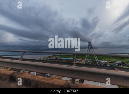 Coucher de soleil nuageux depuis le pont Jules Wijdenbosch au-dessus du fleuve Suriname entre la capitale Paramaribo et Meerzorg dans le district de Commewijne. Banque D'Images