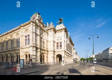 Photo en exposition prolongée de l'Opéra national de Vienne (Wiener Staatsoper) avec des gens et de la circulation passant en Autriche. Banque D'Images