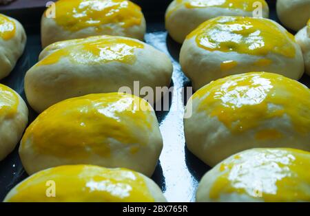Petits pains ronds ovales faits main avec garniture préparée pour la cuisson Banque D'Images