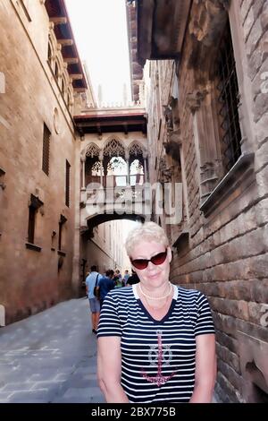 Femme dans le quartier gothique de Barcelone sous le pittoresque pont-balcon, appelé “l'arche des Soupirs” Banque D'Images