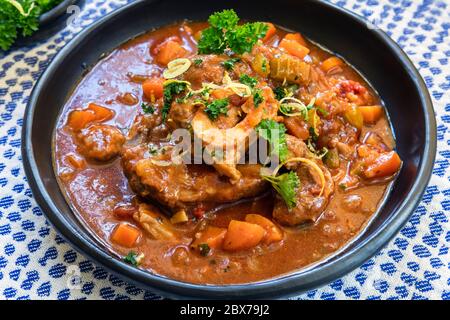 Osso Buco jarret de veau cocotte avec gremolata, dans un bol noir rustique. Banque D'Images