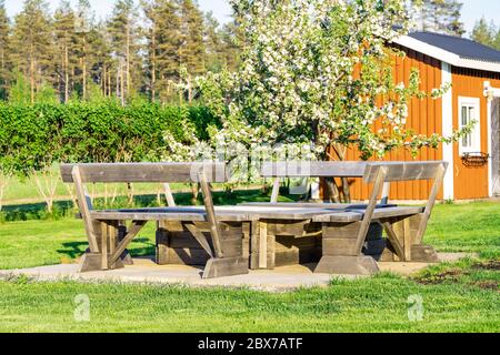 Coin barbecue en bois élégant avec bancs et table debout sur des plaques de béton au milieu du jardin suédois vert, en été. Vasterbotte Banque D'Images