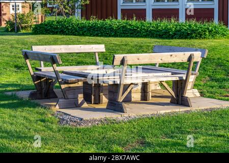 Coin barbecue en bois élégant avec bancs et table debout sur des plaques de béton au milieu du jardin suédois vert, en été. Vasterbotte Banque D'Images