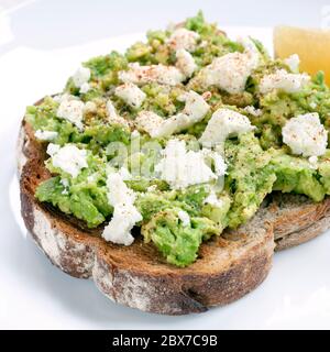 Toast à l'avocat avec fromage feta et citron. Banque D'Images