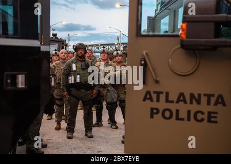 Atlanta, États-Unis. 04e juin 2020. Les gardes nationaux de Géorgie se tiennent avec les membres de l'équipe SWAT de la ville d'Atlanta pour faire respecter un couvre-feu après des jours de manifestations et d'émeutes à la suite de la mort de George Floyd près du parc olympique Centennial le 4 juin 2020 à Atlanta, Géorgie. Floyd a été étouffé par la police à Minneapolis, ce qui a entraîné des manifestations qui ont balayé le pays. Crédit : MSGT. Roger Parsons/Garde nationale/Alamy Live News Banque D'Images