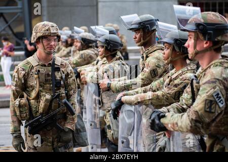 Atlanta, États-Unis. 04e juin 2020. Les gardes nationaux de Géorgie se tiennent avec les membres de l'équipe SWAT de la ville d'Atlanta pour faire respecter un couvre-feu après des jours de manifestations et d'émeutes à la suite de la mort de George Floyd près du parc olympique Centennial le 4 juin 2020 à Atlanta, Géorgie. Floyd a été étouffé par la police à Minneapolis, ce qui a entraîné des manifestations qui ont balayé le pays. Crédit : MSGT. Roger Parsons/Garde nationale/Alamy Live News Banque D'Images