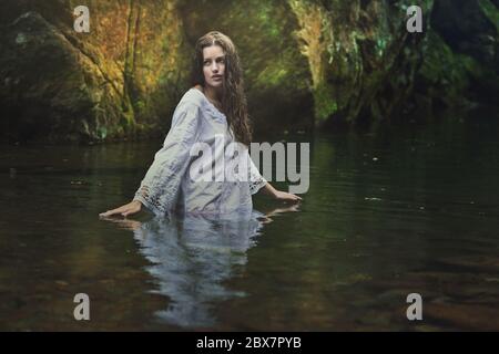Belle femme dans un ruisseau magique sombre . Fantaisie et concept surréaliste Banque D'Images