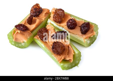 Fourmis sur une bûche, céleri avec beurre d'arachide et raisins secs, isolés sur blanc. Collations saines. Banque D'Images