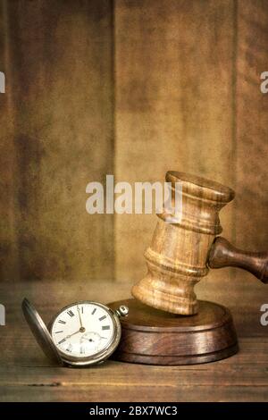 Concept de temps et de justice. Vieille montre de poche avec un gavel en bois, avec fond en bois. Ajout d'effets de grunge. Banque D'Images