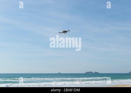 Drone volant dans le ciel bleu sur la plage tropicale au Brésil avec la mer et l'île en arrière-plan. Drone volant dans un ciel bleu ciel nuageux. Drone quad cop Banque D'Images