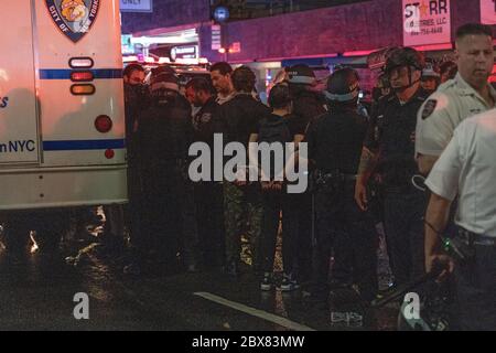 NEW YORK, NY - 03 JUIN : les manifestants à la main sont alignés et traitent avant d'être conduits dans un bus correctionnel sur les lieux d'une arrestation de masse de manifestants Banque D'Images