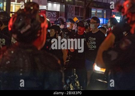 NEW YORK, NY - 03 JUIN : les manifestants à la main sont alignés et traitent avant d'être conduits dans un bus correctionnel sur les lieux d'une arrestation de masse de manifestants Banque D'Images