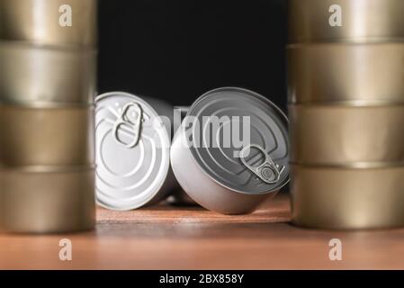 boîtes de thon incliné en argent à l'avant avec pyramide de beaucoup de boîtes sur les côtés couleur or Banque D'Images