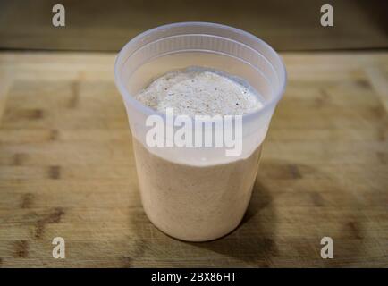 Blanc pétillant et levain de blé de départ après l'alimentation, en préparation pour mélanger la pâte pour le pain rustique artisanal de levain, série photo Banque D'Images