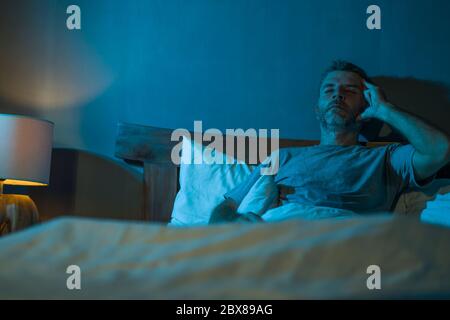 portrait dramatique dans l'obscurité d'un homme déprimé et inquiet sur le lit souffrant de la crise de dépression et l'anxiété se sentant perdu couché sans sommeil en moi Banque D'Images