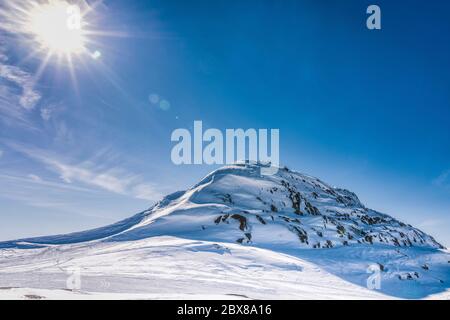 Vue sur la montagne d'Atoklinten à Lappland, nord de la Suède, face avant. Tous les motoneiges y conduisent. Un soleil brillant brille à gauche, sur le côté supérieur, de la sn beaucoup de blanc Banque D'Images