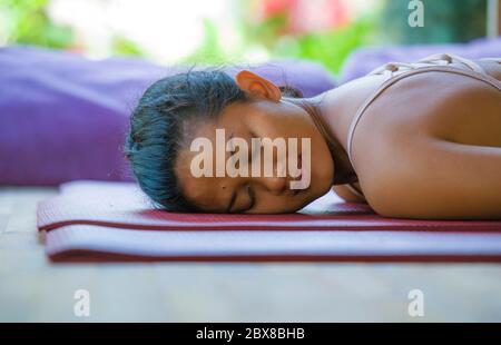 Portrait naturel de jeune femme asiatique indonésienne, belle et exotique, couché sur un tapis de studio à l'atelier de yoga avec les yeux à proximité dans la maison de méditation Banque D'Images
