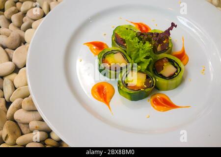 Cuisine gastronomique japonaise - en gros plan et détail sur un délicieux et délicat plat de petits pains à sushis japonais en ardoise sur fond de pierre dans un cadre traditionnel sain Banque D'Images