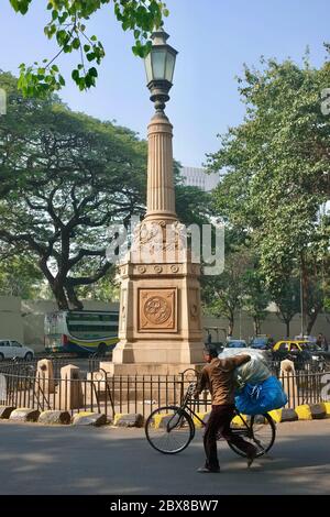 Un homme pousse son vélo devant le Mémorial de la première Guerre mondiale de Port Trust à Ballard Estate, Mumbai (Bombay), Inde Banque D'Images