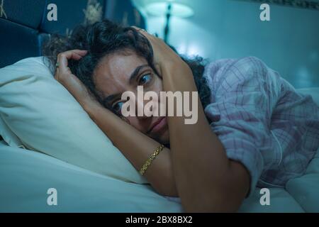 style de vie nocturne dramatique potrait de jeune triste et déprimé moyenne-orientale avec les cheveux bouclés sans sommeil dans le lit éveillé sentiment inquiet souffrant deprr Banque D'Images