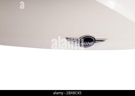 Une plaque signalétique élégante d'une marque automobile du modèle Mini Cooper sur le capot d'un capot blanc en matériau noir avec éléments chromés et logo. Banque D'Images