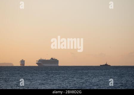 Weymouth, Royaume-Uni. 6 juin 2020. Lever du soleil tôt le matin au-dessus des navires de croisière AZURA et VENTURA, et un navire naval dans la baie de Weymouth. Banque D'Images