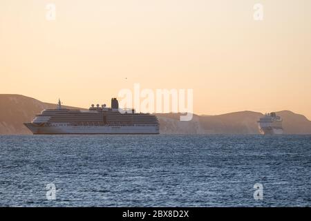 Weymouth, Royaume-Uni. 6 juin 2020. Lever du soleil tôt le matin sur les navires de croisière ARCADIA et BRITANNIA dans la baie de Weymouth. Banque D'Images