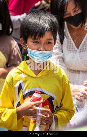 Garçon avec masque facial à la banque alimentaire gratuite pendant la pandémie de Covid, Bangkok, Thaïlande Banque D'Images