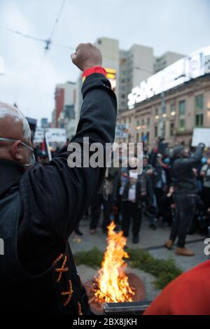 Melbourne, Australie. 06e juin 2020. Un manifestant australien indigène lève un poing alors qu'un incendie est allumé pour conduire une cérémonie de tabagisme comme signe de respect du passé et du présent des aînés et de l'outsider de la station de Flinders Street lors d'un rassemblement de protestation appelant à un arrêt des morts noires en détention et en justice Pour George Floyd qui a eu lieu à Melbourne, en Australie aujourd'hui. 06 juin 2020 crédit : Michael Currie/Alay Live News Banque D'Images