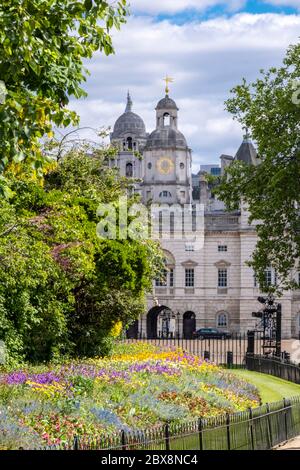 Royaume-Uni, Angleterre, Londres. Bâtiment des gardes-chevaux du parc St. James montrant les fleurs printanières dans les lits de fleurs Banque D'Images